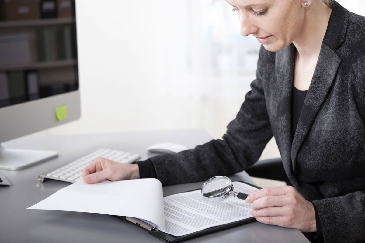 Article image of woman analyzing a document